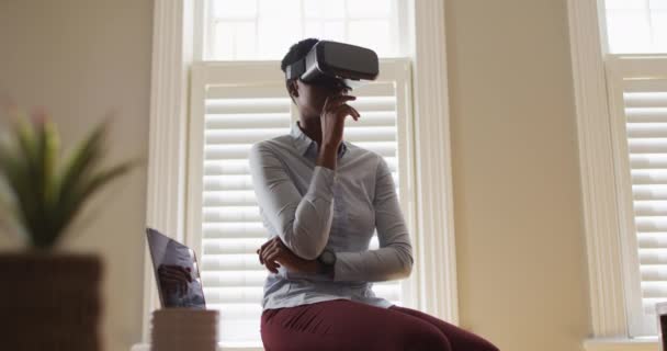 Afro-americano mulher fazendo mão gestos enquanto usando vr fone de ouvido em casa — Vídeo de Stock