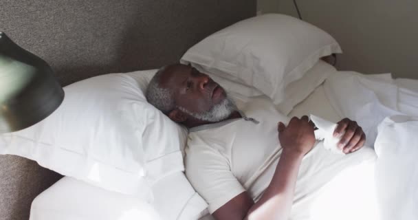 Άρρωστος ηλικιωμένος Αφροαμερικάνος που κάνει καναπέδες ξαπλωμένος στο κρεβάτι στο σπίτι. — Αρχείο Βίντεο