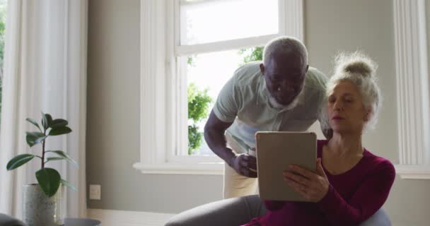 Smíšené závod senior pár pomocí digitální tablet v obývacím pokoji doma — Stock video