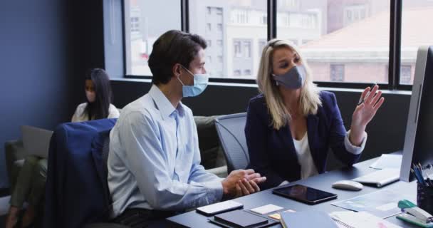 Διαφορετικοί Επιχειρηματίες Που Φορούν Μάσκες Προσώπου Χρησιμοποιώντας Υπολογιστή Στο Γραφείο — Αρχείο Βίντεο
