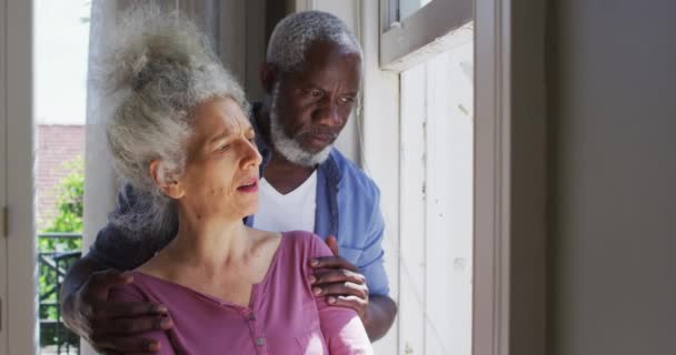 Mixte couple senior course parler entre eux tout en regardant par la fenêtre à la maison — Video