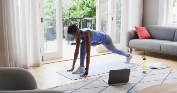 Mujer afroamericana realizando ejercicio de estiramiento en casa — Vídeo de stock
