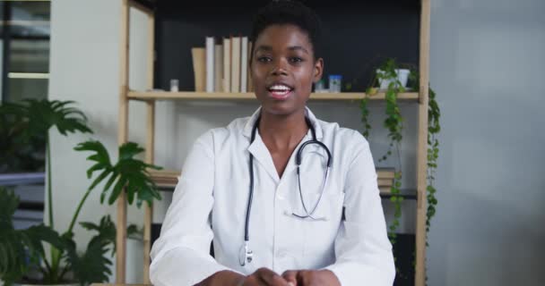 Retrato de la mujer afroamericana doctora teniendo un video chat hablando y sonriendo — Vídeos de Stock