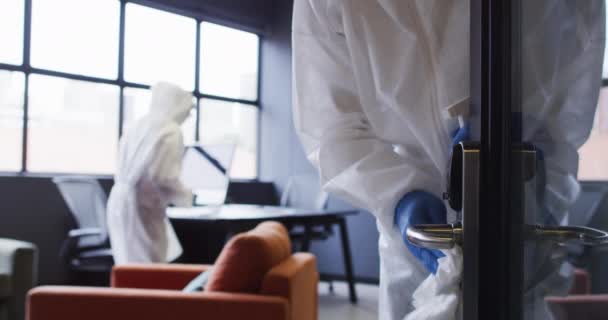 Curatatorii care poarta haine de protectie dezinfecteaza spatiul modern de birouri — Videoclip de stoc