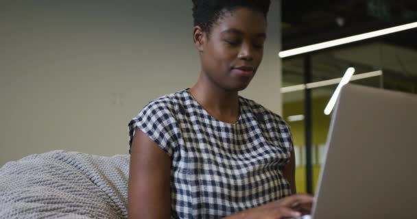 Afričanky americká podnikatelka sedí za stolem pomocí notebooku v kanceláři — Stock video