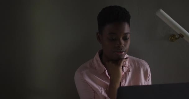 Mujer afroamericana usando portátil mientras trabaja desde casa — Vídeos de Stock