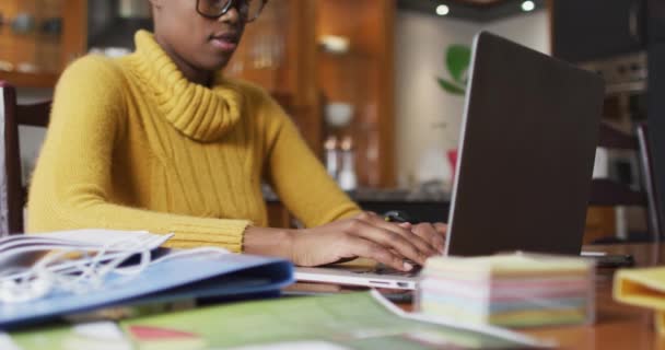 Mujer afroamericana usando portátil mientras trabaja desde casa — Vídeos de Stock