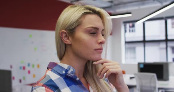 白人ビジネスマン女性こすり彼女のあごで考えと笑顔でオフィス — ストック動画