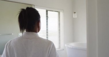 Banyodaki melez kadının bornozunu çıkarması.