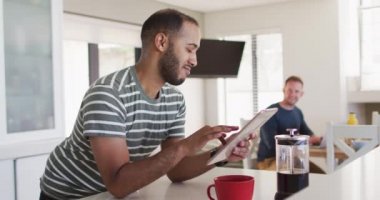 Mutfaktaki çok ırklı eşcinsel çift tablet kullanıyor.