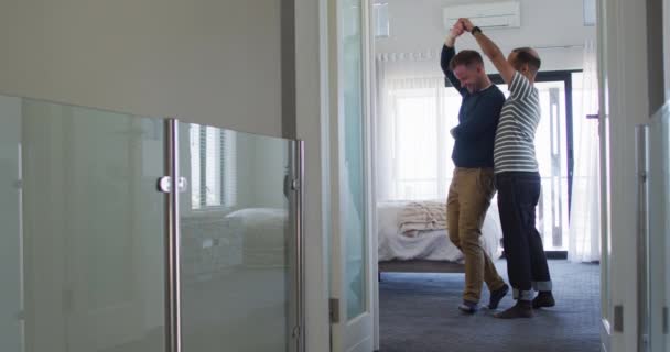 Multi ethnisch gay männlich pärchen having spaß tanzen im schlafzimmer — Stockvideo