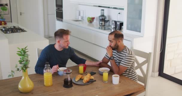 Multi etnische gay man paar zitten met ontbijt en praten — Stockvideo