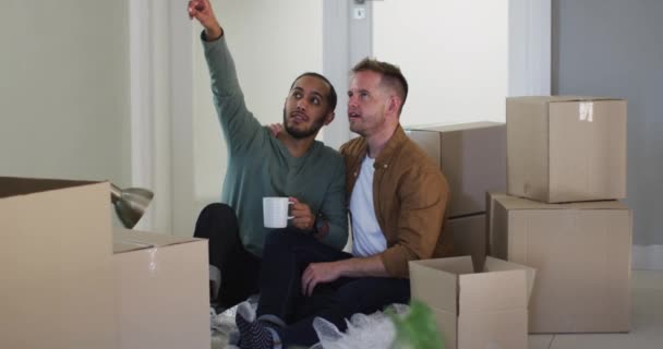 多种族的男同性恋夫妇一边喝咖啡 一边打包搬家 在隔离隔离的环境中独自待在家里 — 图库视频影像