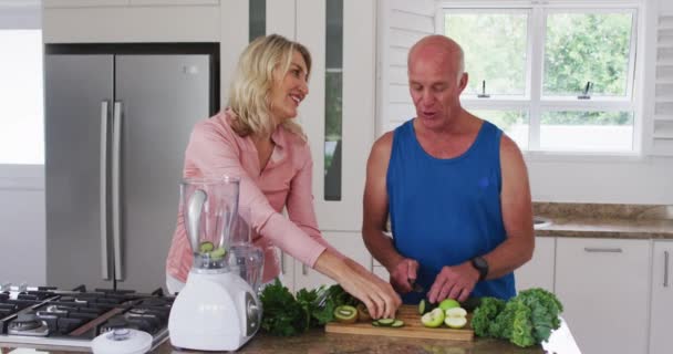 自宅で果物や野菜の健康飲料を準備するシニア白人男性と女性 老人ホームでの健康フィットネス — ストック動画