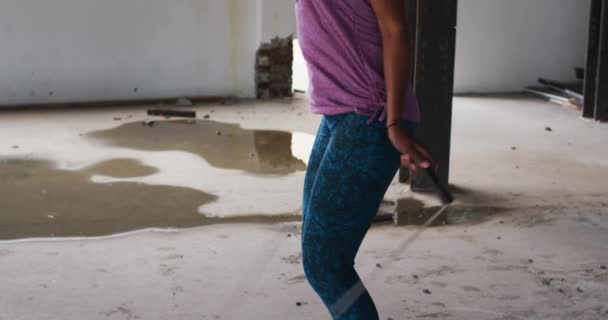 Afričanky americká žena s kapucí skákání lano v prázdné městské budově — Stock video