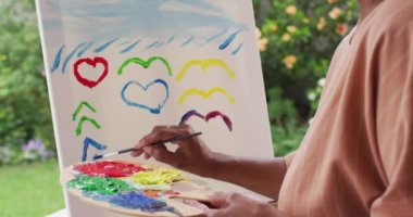 Evin verandasında dikilirken son sınıf Afro-Amerikan kadın portresi.