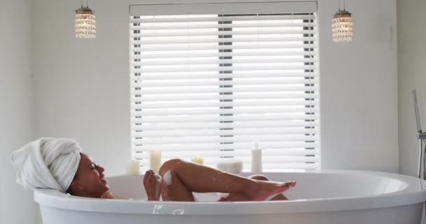 Afro american femeie suflare săpun bule în cada de baie în baie la domiciliu — Videoclip de stoc