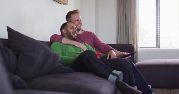 Multi etnico gay maschio coppia seduta su divano e guardando la tv — Video Stock