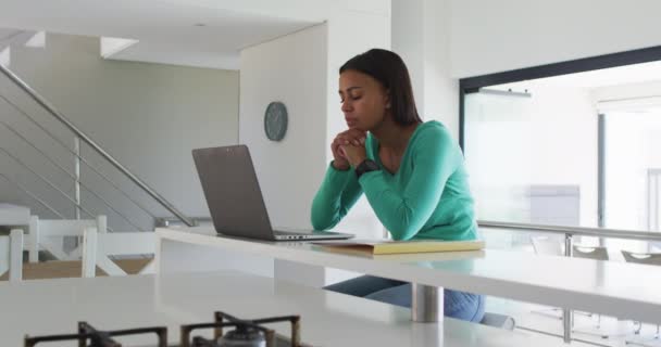 Αφροαμερικανή γυναίκα που χρησιμοποιεί φορητό υπολογιστή ενώ εργάζεται από το σπίτι — Αρχείο Βίντεο