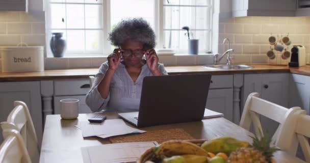 Stressato anziana donna afroamericana utilizzando il computer portatile e calcolando le finanze a casa — Video Stock