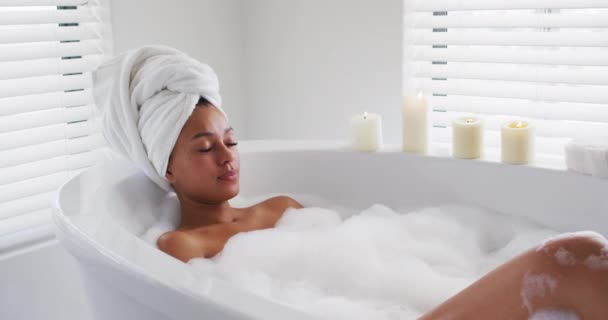 Femeia afro-americană se relaxează în cada de baie din baie acasă — Videoclip de stoc