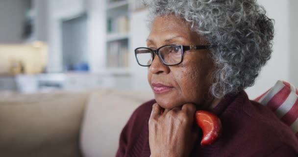 Tankevækkende seniorafrikansk kvinde med stok siddende på sofaen derhjemme – Stock-video