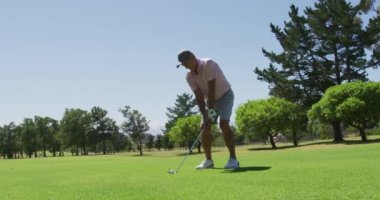 Güneşli bir günde golf sahasında golf antrenmanı yapan beyaz bir adam. emeklilik sporları ve aktif yaşlı yaşam tarzı.