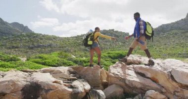 Afrika kökenli Amerikalı çiftler el ele tutuşuyorlar ve yürürken kayalarda yürüyorlar.