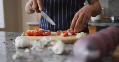 Kafkasyalı son sınıf öğrencisinin önlük giyip evde sebze doğradığı orta bölüm.