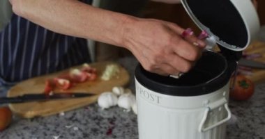 Kafkasyalı yaşlı kadının orta bölümü evdeki mutfaktaki çöp kutusuna atılıyor.