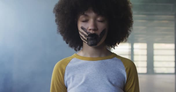 Retrato de mulher afro-americana com marca de mão na boca em pé na garagem vazia — Vídeo de Stock