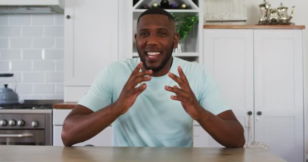 Hombre afroamericano mirando a la cámara hablando en videollamada en la cocina — Vídeo de stock