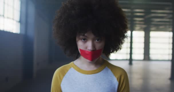 Retrato de mujer afroamericana con cinta roja en la boca en estacionamiento vacío — Vídeos de Stock