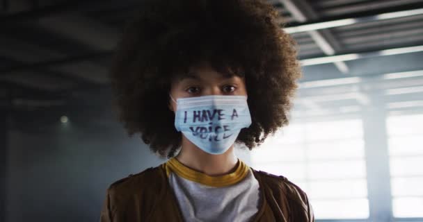 Protesto maskesi takan Afrikalı Amerikalı kadın portresi boş otoparkta dur işareti yapıyor. — Stok video
