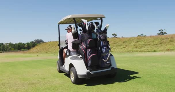 Kaukázusi Végzős Pár Golfkocsit Vezet Ütőkkel Hátán Golfpályán Nyugdíjas Sportok — Stock videók