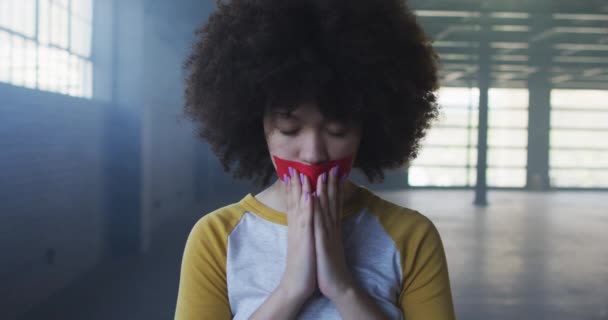Boş otoparkta ağzında kırmızı bant olan Afrikalı Amerikalı bir kadının portresi. — Stok video