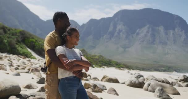 Африканська американська пара обіймає одне одного під час прогулянок у горах. — стокове відео