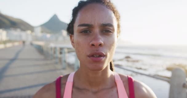 Portret afrykańskiej kobiety w odzieży sportowej spoczywającej na promenadzie nad morzem — Wideo stockowe