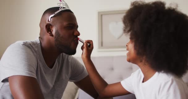 アフリカ系アメリカ人の女の子applying口紅に彼女の父身に着けていますクラウンにホーム — ストック動画