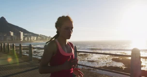 Afrikai amerikai nő fut sétány a tenger naplementekor — Stock videók