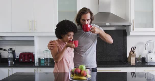 自宅のキッチンで一緒に混合レースカップルコーヒーを飲む 隔離されたまま家にいると — ストック動画