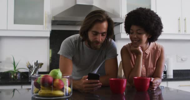 Couple Mixte Tenant Des Tasses Café Utilisant Smartphone Dans Cuisine — Video