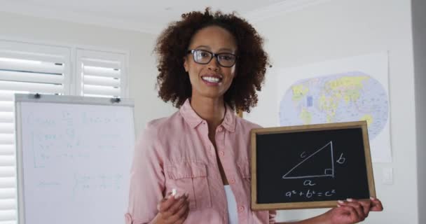 Mieszane rasy nauczyciel kobieta stoi na tablicy daje lekcję online do kamery — Wideo stockowe