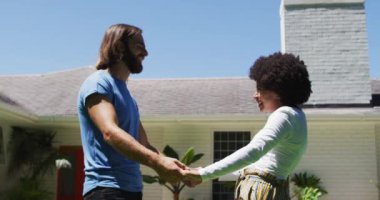 Yeni apartmanın yakınında birbirine sarılan mutlu melez çift. Taşınma ve emlak konsepti