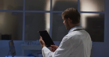 Kafkas erkek doktor tablet bilgisayar kullanarak video görüşmesi yapıyor. Karantina süresince teletıp çevrimiçi sağlık hizmetleri.