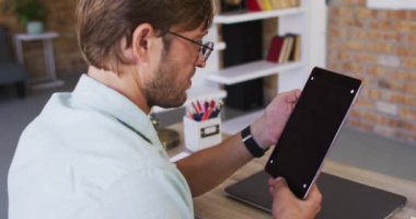 Beyaz erkek öğretmen okuldaki sınıfta dijital tabletle ilgili bir video görüşmesi yapıyor. uzak öğrenim çevrimiçi eğitim