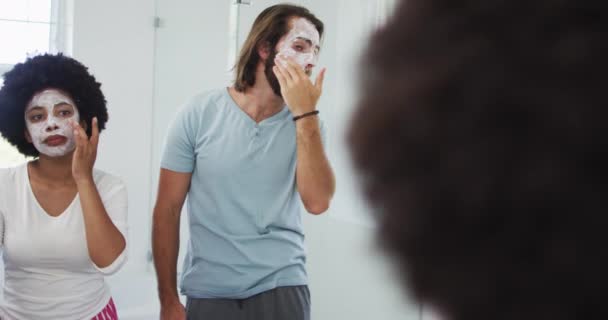 Couple Mixte Appliquant Masque Facial Ensemble Tout Regardant Dans Miroir — Video