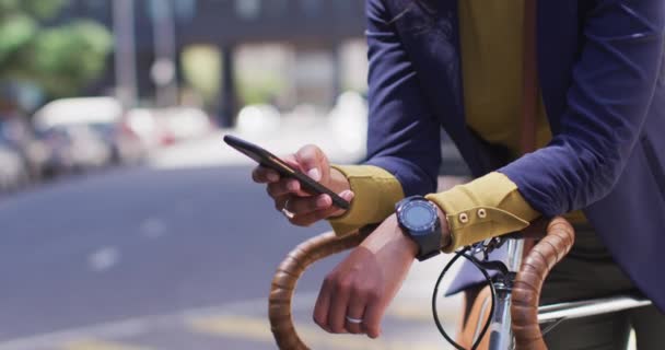 アフリカ系アメリカ人の女性が路上で自転車にもたれてスマートフォンを使う デジタル ノマドや街中で — ストック動画