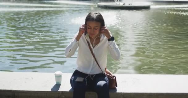 Mujer Afroamericana Poniéndose Auriculares Parque Ciudad Nómada Digital Ciudad — Vídeos de Stock