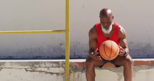 Hombre Afroamericano Mayor Haciendo Ejercicio Sentado Jugando Con Baloncesto Concepto — Vídeo de stock